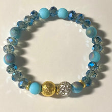 Load image into Gallery viewer, Blue Skies II - Light blue iridescent ceramic beads with dark teal blue crystals, gold disc spacers, and white crystal pavé bead