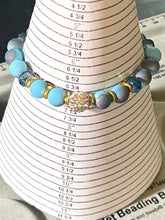 Load image into Gallery viewer, Blue Skies - Light blue iridescent ceramic beads with dark teal blue crystals, gold disc spacers, and white crystal pavé bead