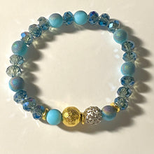 Load image into Gallery viewer, Blue Skies II - Light blue iridescent ceramic beads with dark teal blue crystals, gold disc spacers, and white crystal pavé bead
