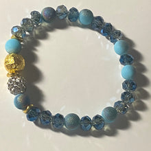 Load image into Gallery viewer, Blue Skies II - Light blue iridescent ceramic beads with dark teal blue crystals, gold disc spacers, and white crystal pavé bead
