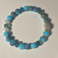 Load image into Gallery viewer, Blue Skies - Light blue iridescent ceramic beads with dark teal blue crystals, gold disc spacers, and white crystal pavé bead
