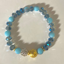 Load image into Gallery viewer, Blue Skies II - Light blue iridescent ceramic beads with dark teal blue crystals, gold disc spacers, and white crystal pavé bead
