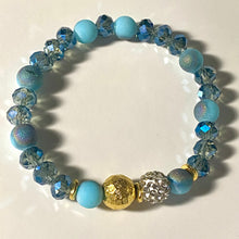 Load image into Gallery viewer, Blue Skies II - Light blue iridescent ceramic beads with dark teal blue crystals, gold disc spacers, and white crystal pavé bead
